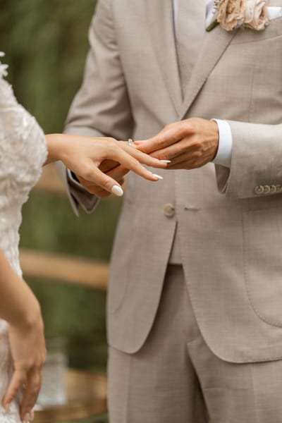 Close-up van de ringwissel: Dominique en Daimy schuiven de trouwring om de vinger tijdens de ceremonie