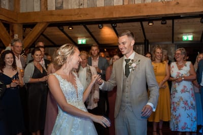 Danny en Esmee openen lachend de dansvloer terwijl de gasten in een kring om hen heen staan te kijken